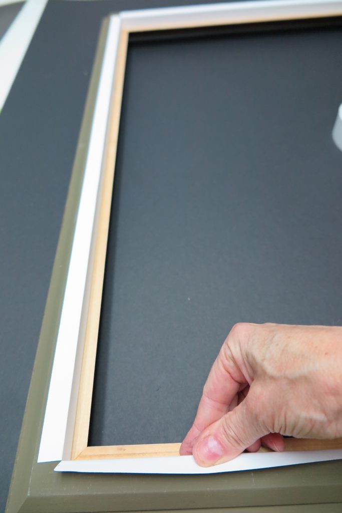 hand placing frame-sealing tape to the rabbet.