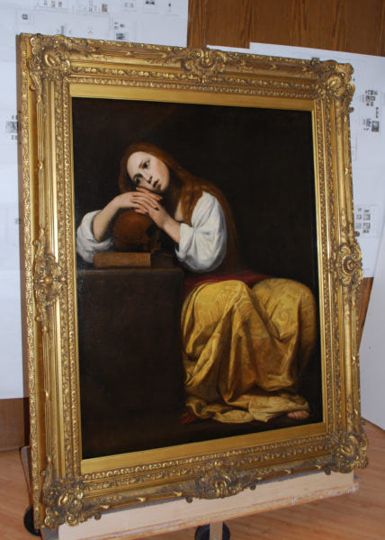 Large framed oil painting with ornate gold frame displayed in a conservation or restoration setting.