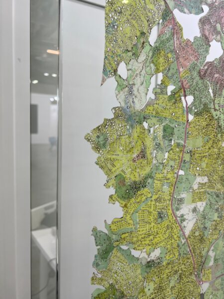 Close up view of the topographical pieces through Optium Museum Acrylic display case fabricated by Q Framing.