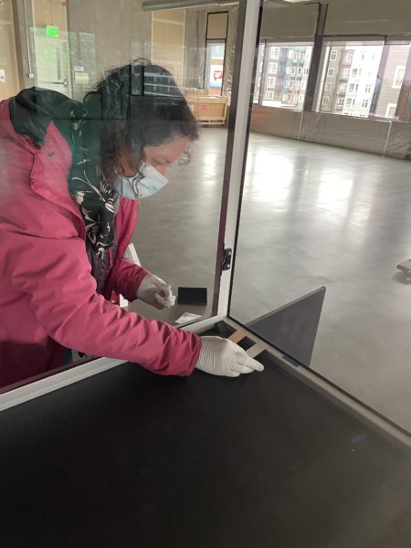 Conservator Lisa Duncan, places silver, copper and lead coupons in the case for off-gassing assessment in the first couple months after completion. Photo courtesy of MoPOP.