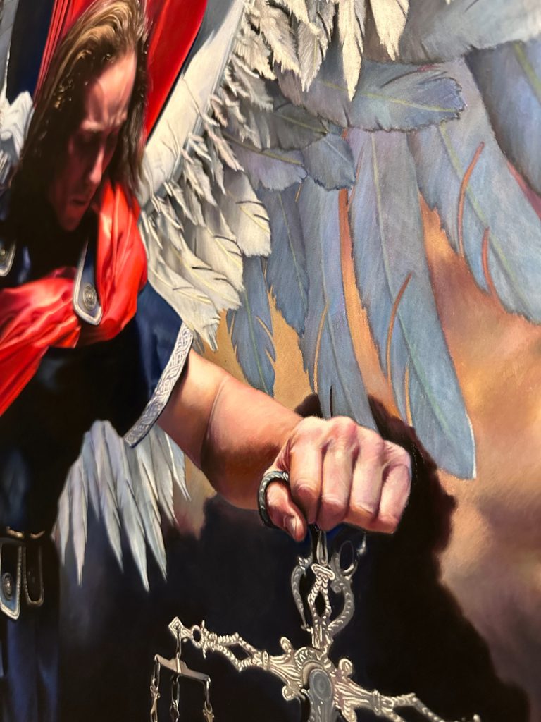 Detail of a pastel painting depicting Saint Michael holding scales, highlighting delicate textures, layered pigments, and subtle color transitions.