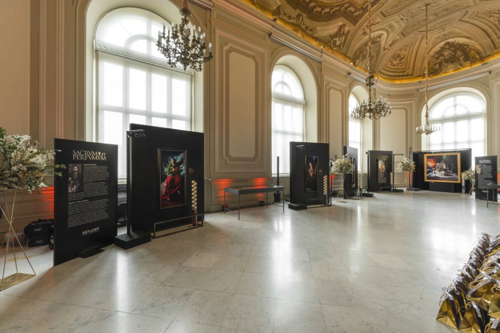 Fine art exhibition in Turin featuring framed pastel paintings displayed in a historic gallery setting.